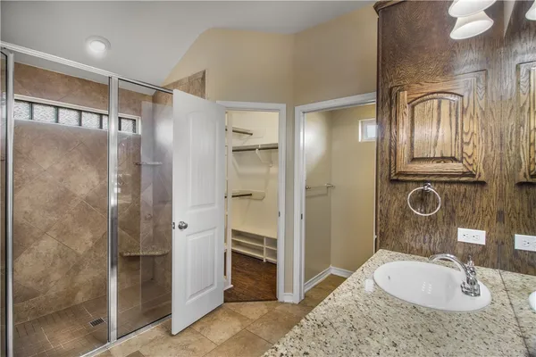 a bathroom with a granite countertop sink mirror and shower