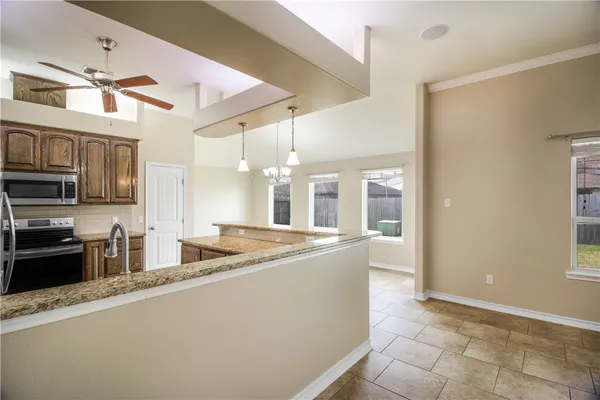 a kitchen with stainless steel appliances granite countertop a sink and a refrigerator