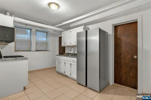 a kitchen with stainless steel appliances granite countertop a refrigerator and a stove
