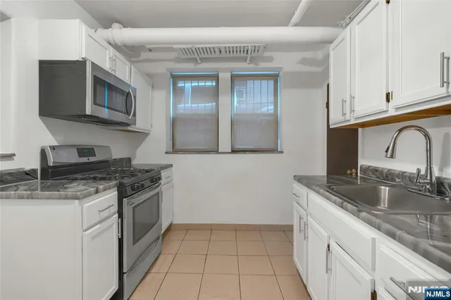 a kitchen with stainless steel appliances granite countertop a sink stove and cabinets