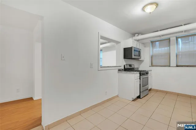 a kitchen with white cabinets and appliances