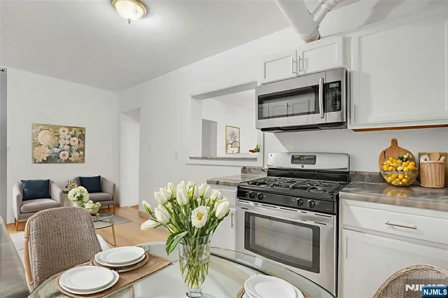 a kitchen with stainless steel appliances a stove a sink cabinets and a refrigerator