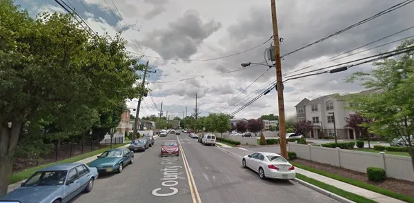 a city street lined with parked cars and buildings