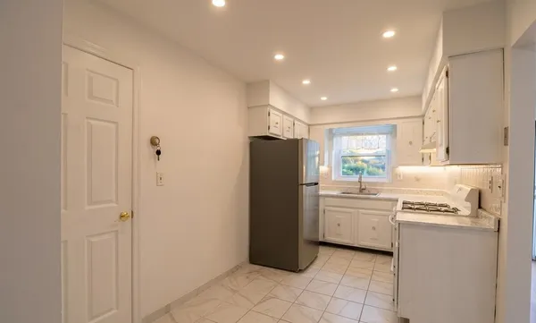 a kitchen with a refrigerator and a stove top oven