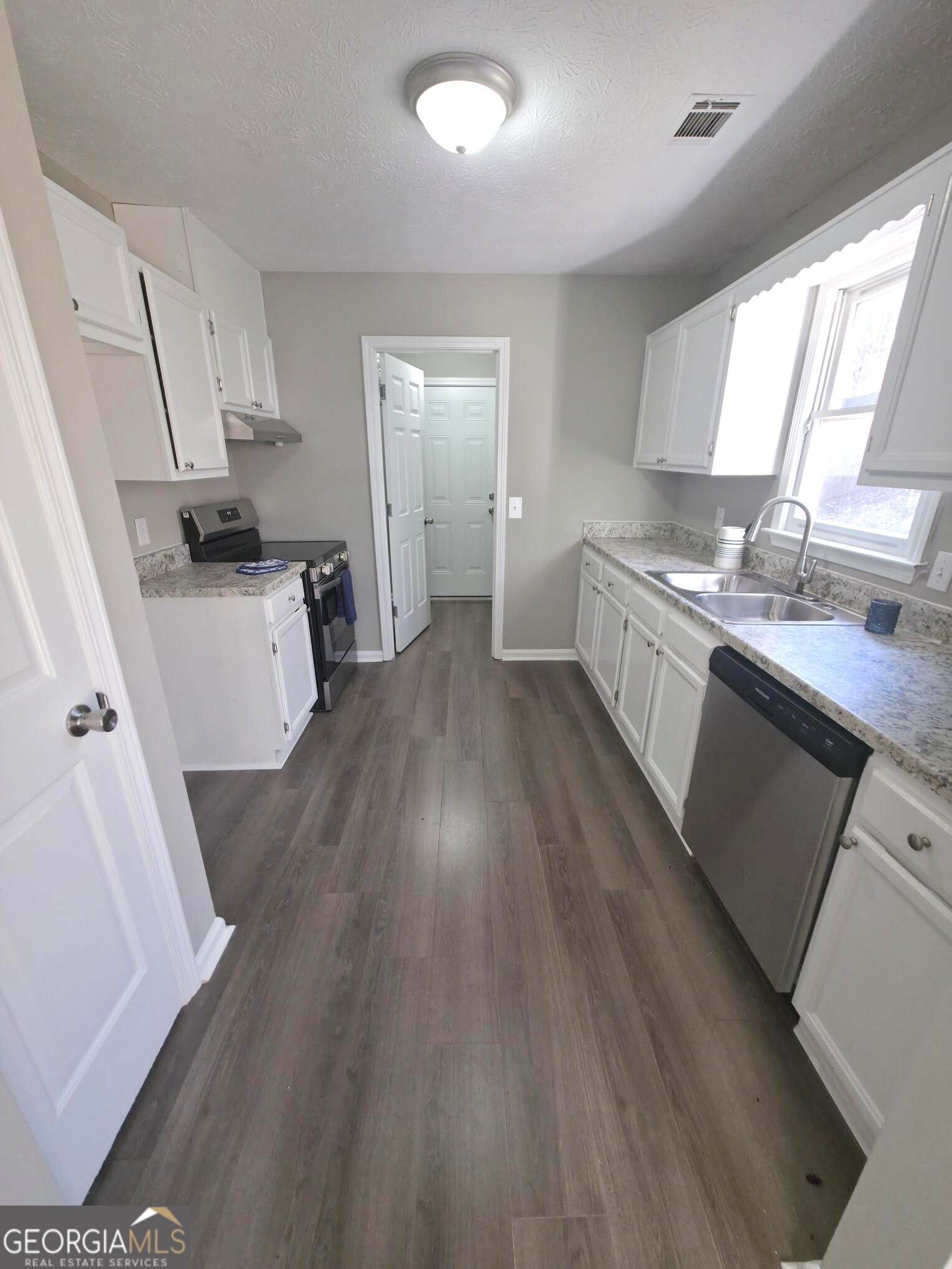 1528 Willow Gate Way Auburn, GA 30011 - Photo 4 of 24 a kitchen with a sink and wooden floor