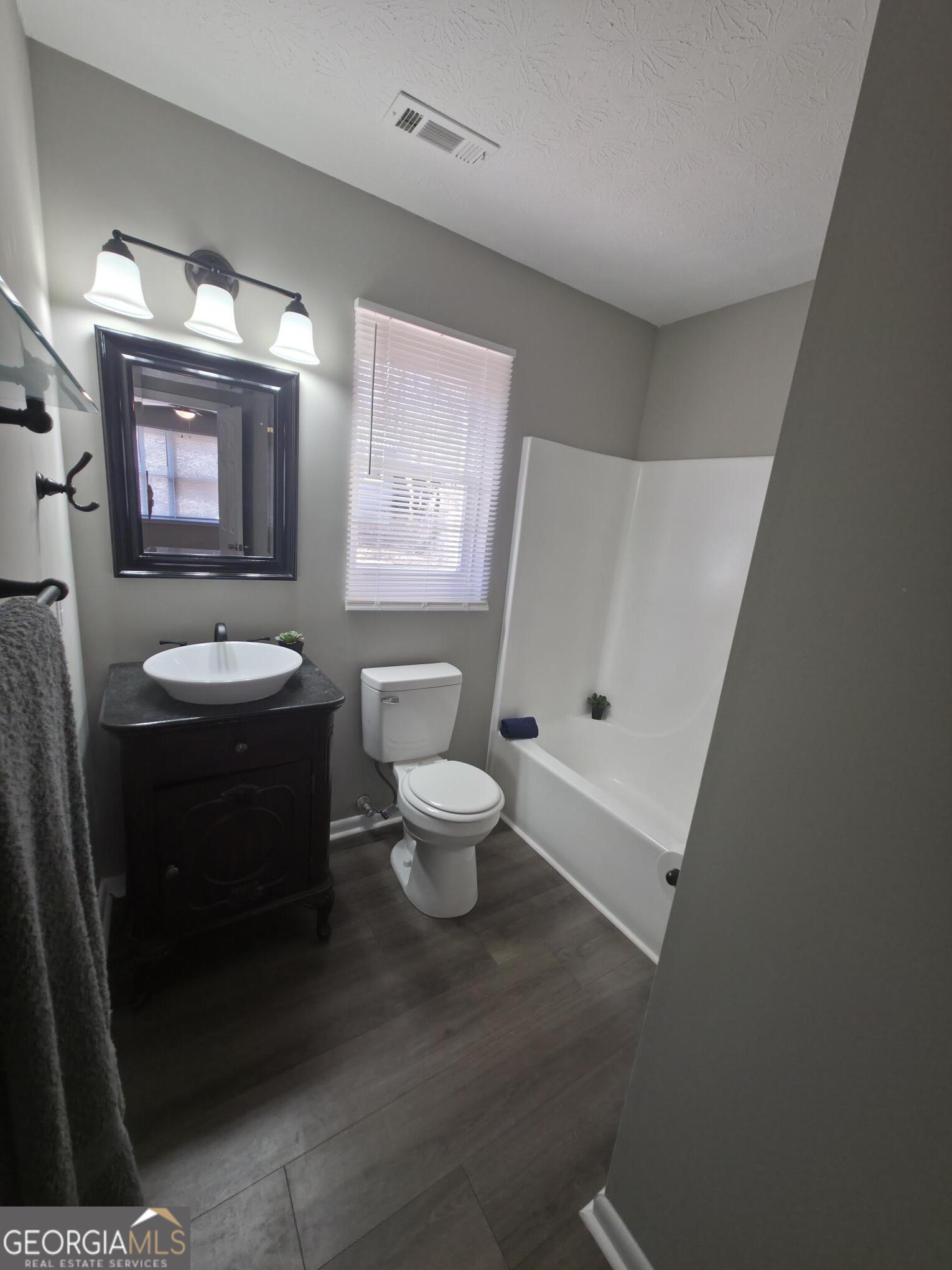 1528 Willow Gate Way Auburn, GA 30011 - Photo 8 of 24 a bathroom with a toilet a sink and a mirror