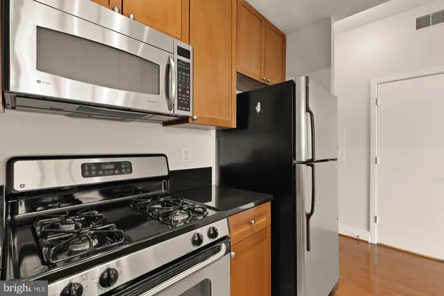 a kitchen with stainless steel appliances granite countertop a refrigerator stove and microwave