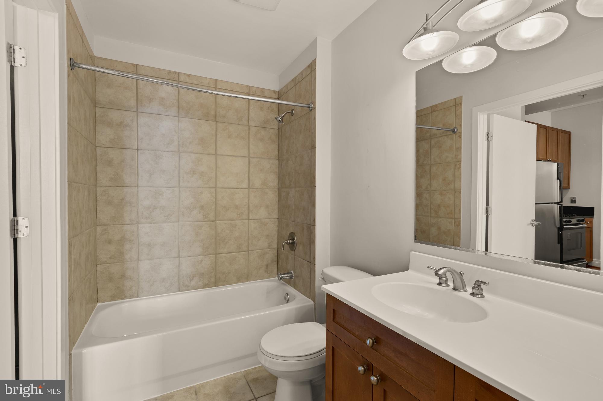 2120 Vermont Avenue Northwest, Unit 411 Washington, DC 20001 - Photo 18 of 27 a bathroom with a bathtub a sink a toilet a mirror and shower