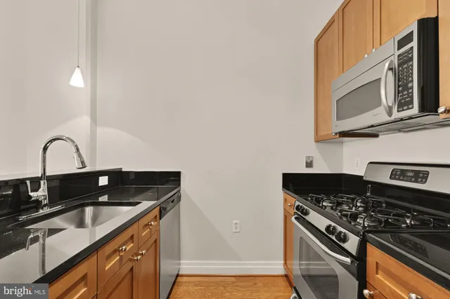 a kitchen with granite countertop a stove and a microwave