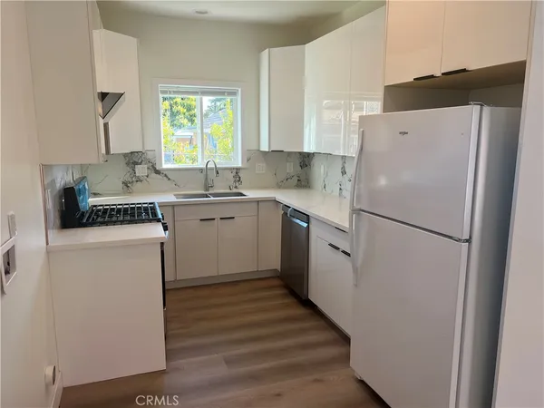 a kitchen with a refrigerator a sink and cabinets