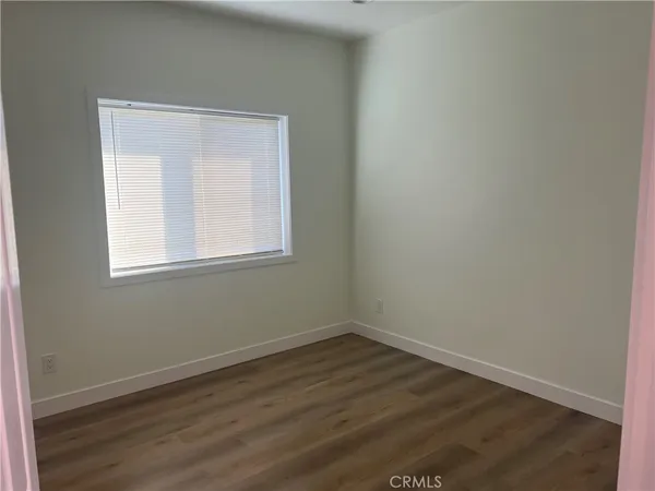 a view of a room that has wooden floor and windows in it
