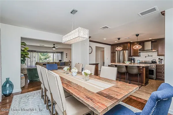 a living room with stainless steel appliances kitchen island granite countertop furniture and a rug