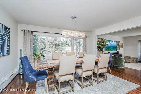 a dining room with furniture a large window and wooden floor