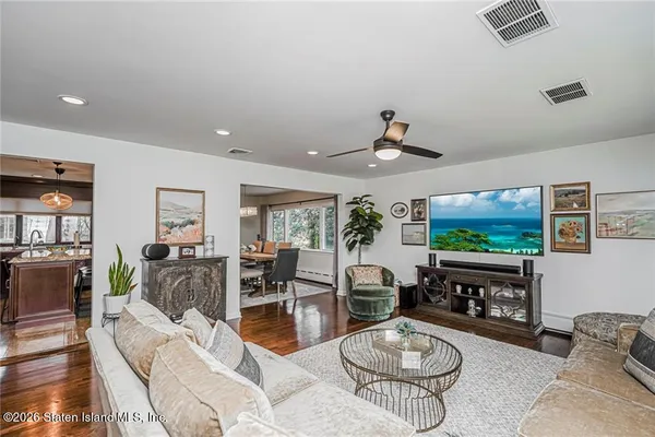 a living room with furniture a flat screen tv and a floor to ceiling window