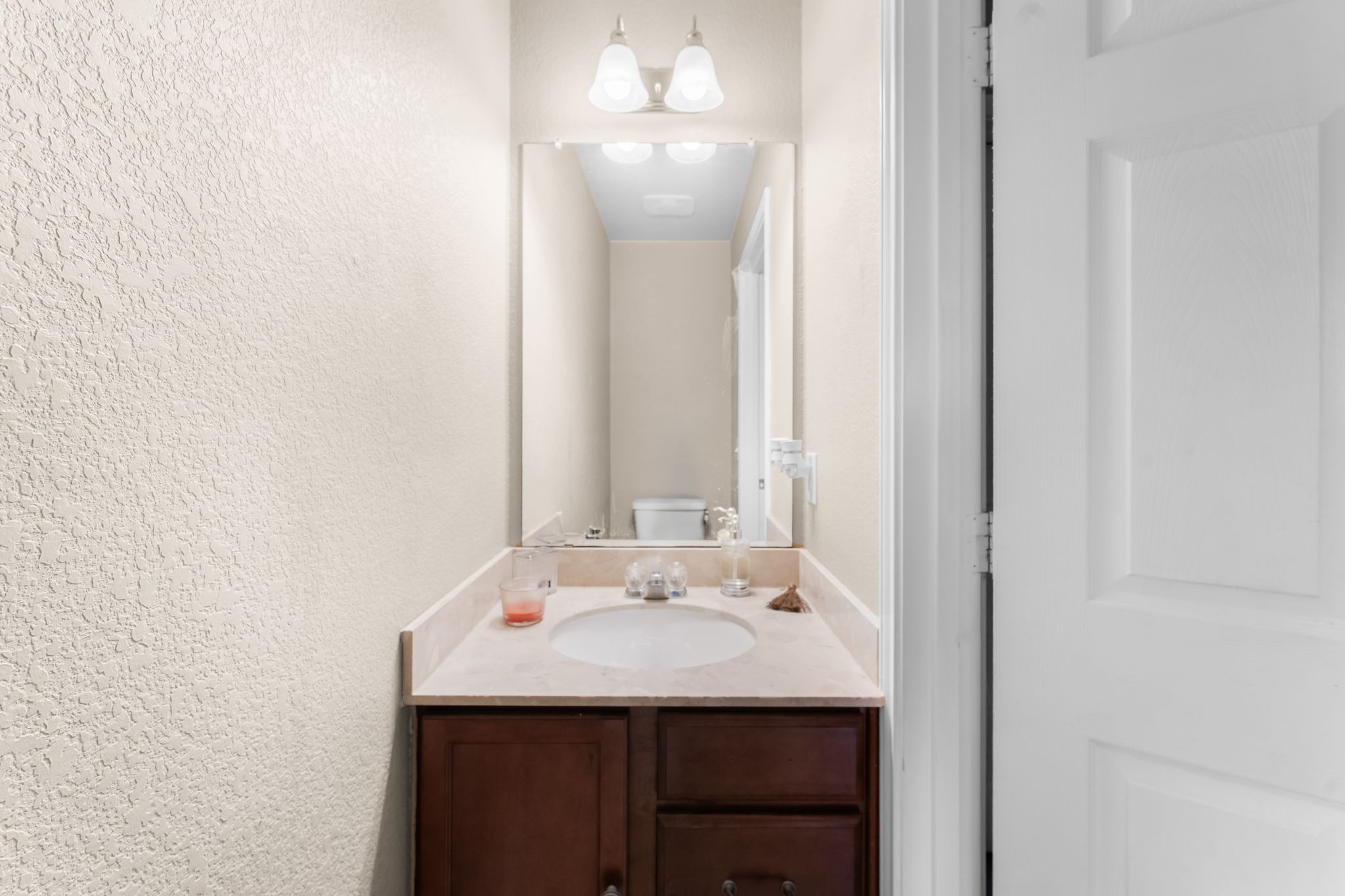 6708 Glebe Path Austin, TX 78754 - Photo 18 of 35 A well-appointed powder room/ half bath features a vanity with a light-colored countertop and a mirror above.
