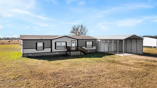 a backyard of a house with yard table and chairs