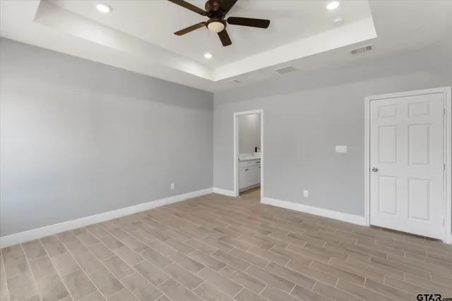 wooden floor in an empty room with a ceiling fan