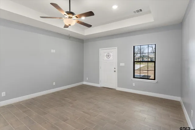 an empty room with fan and windows