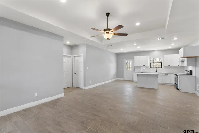 a view of an empty room and kitchen view