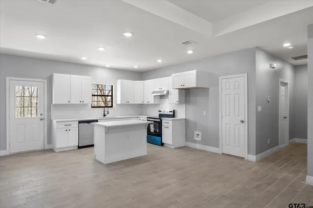 a kitchen with a refrigerator and white cabinets