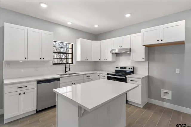 a kitchen with a sink a stove and cabinets