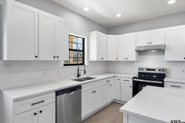a kitchen with a sink a stove and cabinets