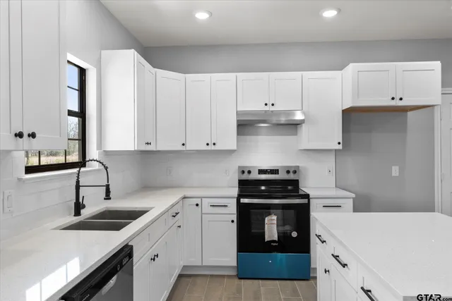 a kitchen with a sink stove and white cabinets