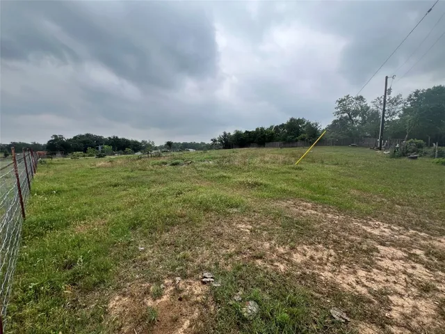 a view of a field with an trees in the background