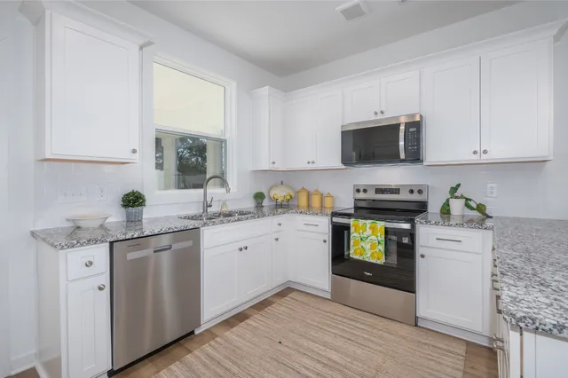 a kitchen with appliances a sink and cabinets