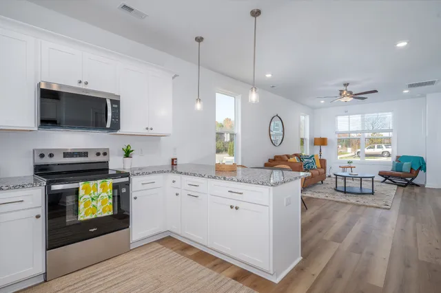 a large kitchen with a wooden floor and stainless steel appliances