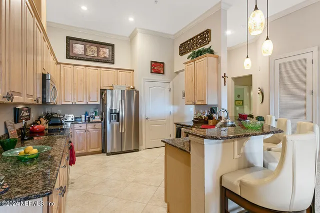 a kitchen with stainless steel appliances granite countertop a refrigerator sink and stove