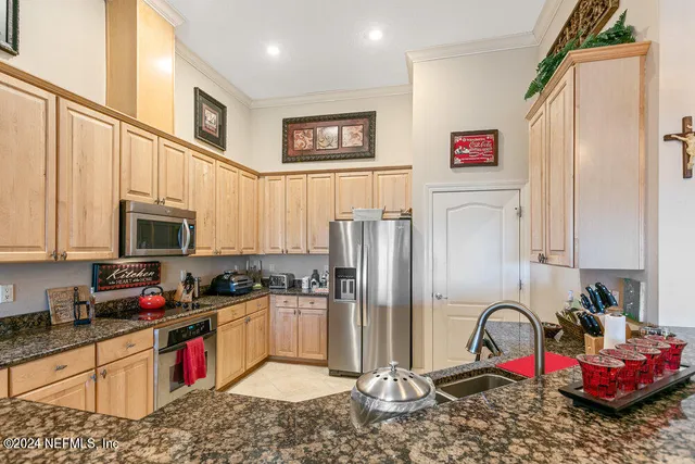a view of a dining room with furniture a chandelier and kitchen view