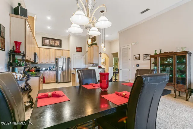 a living room with furniture a chandelier and a dining table