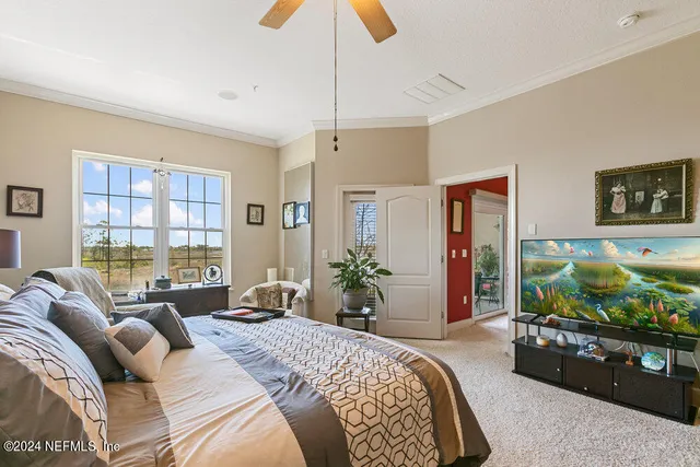 a bedroom with a bed and painting on the wall