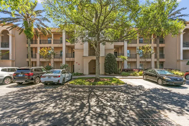 a tall buildings with car parked in front of it
