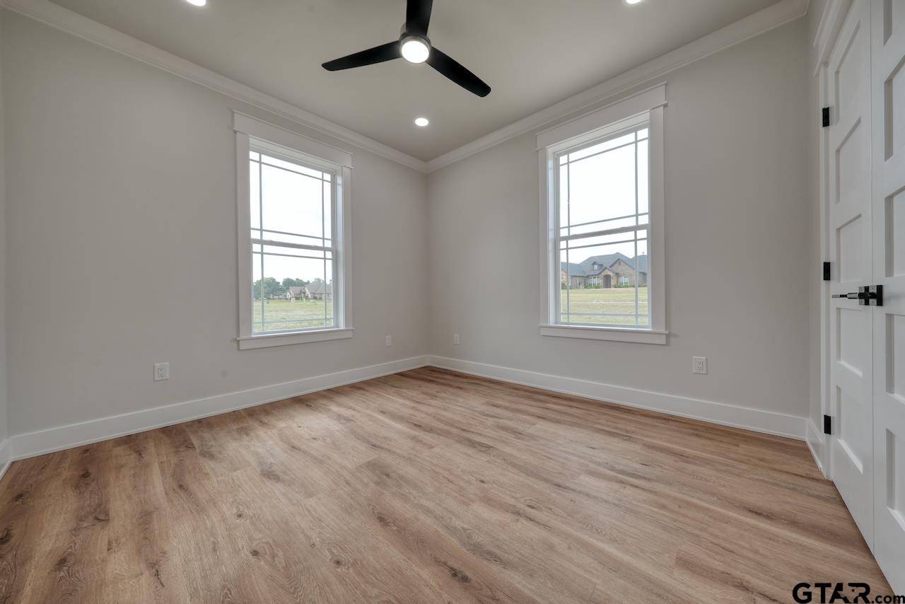 19383 Ridge Point Circle Lindale, TX 75771 - Photo 31 of 48 an empty room with wooden floor ceiling fan and windows