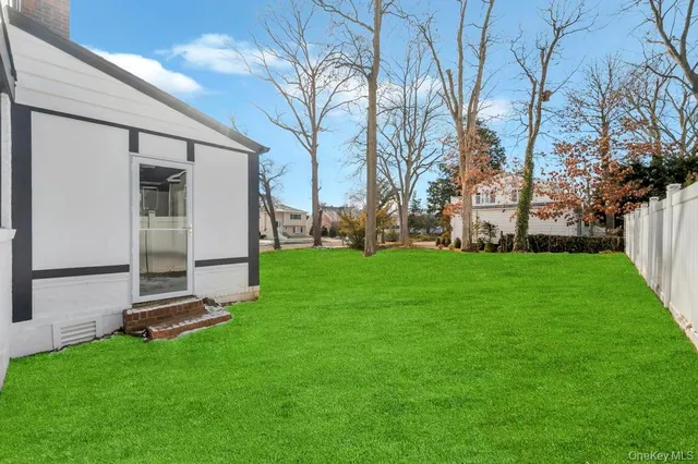a view of a big house with a big yard and large trees