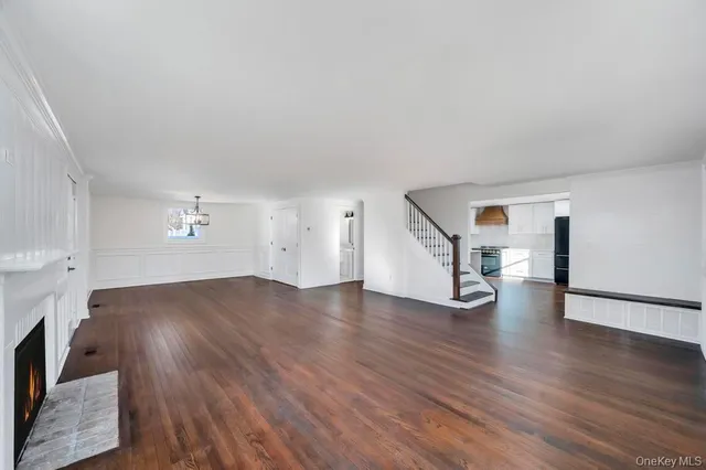 a view of empty room with wooden floor and fireplace