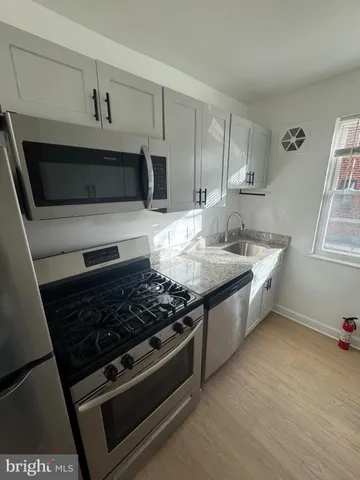 a kitchen with stainless steel appliances granite countertop a stove and a microwave