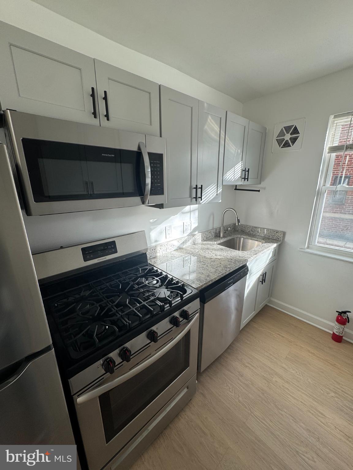 1635 6th Street Northwest, Unit 2 Washington, DC 20001 - Photo 9 of 14 a kitchen with stainless steel appliances granite countertop a stove and a microwave