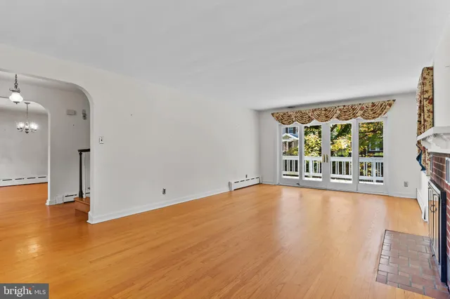 an empty room with windows and fireplace