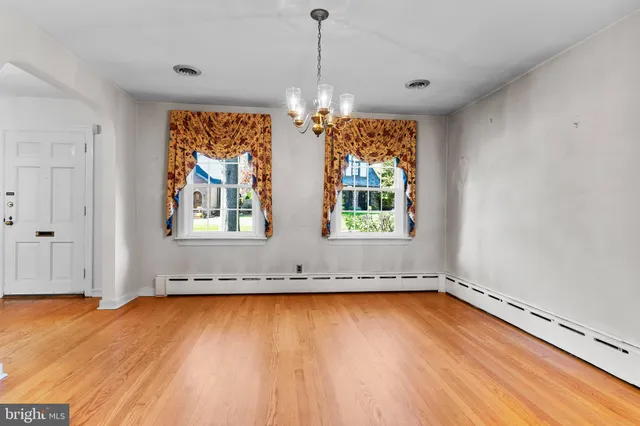 a view of a room with wooden floor and kitchen space
