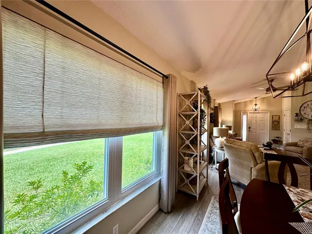 a view of a dining room and livingroom with furniture wooden floor a chandelier