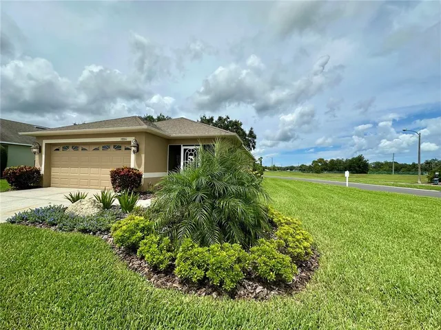 a view of a house with a big yard and large trees