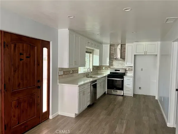 a kitchen with a refrigerator a sink and a stove top oven