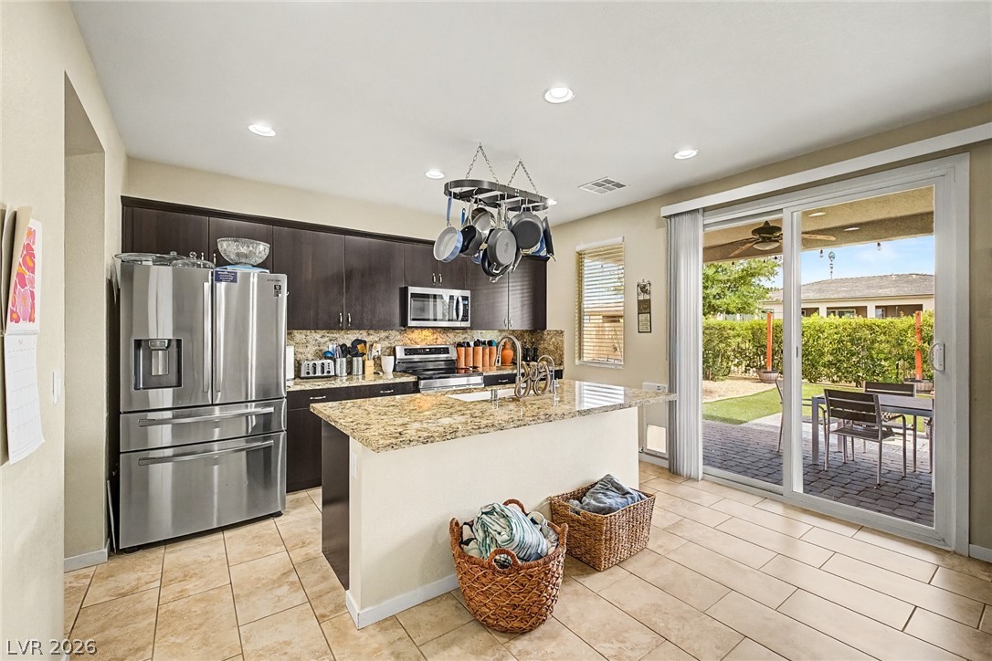 4914 East Beacon Ridge Drive Pahrump, NV 89061 - Photo 12 of 34 Culinary aspirations meet seamless outdoor living in this modern kitchen, complete with a generous island and direct patio access.