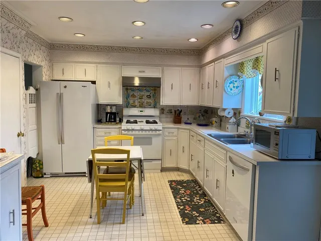 a kitchen with granite countertop a refrigerator stove top oven and sink