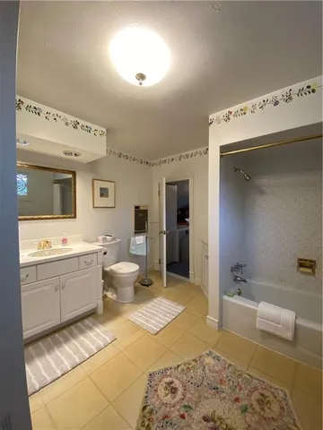 a spacious bathroom with a tub sink and mirror