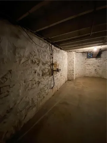 a room with water heater and wooden cabinets