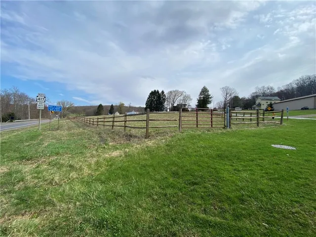 a view of a green field with wooden fence